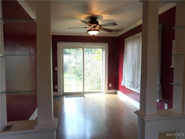 interior space with ceiling fan, light hardwood / wood-style floors, ornate columns, and ornamental molding