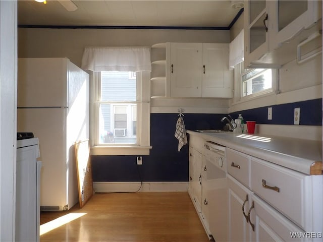 kitchen with white appliances, white cabinetry, plenty of natural light, and sink