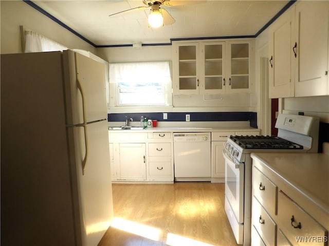 kitchen with white appliances, sink, light hardwood / wood-style flooring, ceiling fan, and white cabinetry