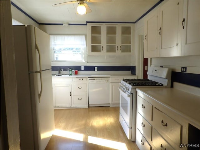 kitchen featuring sink, white cabinets, white appliances, and light wood-type flooring