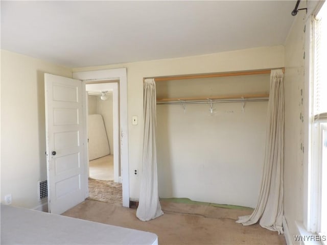 unfurnished bedroom with a closet and light colored carpet