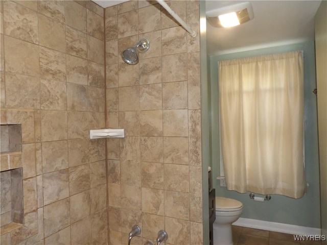 bathroom featuring tiled shower and toilet