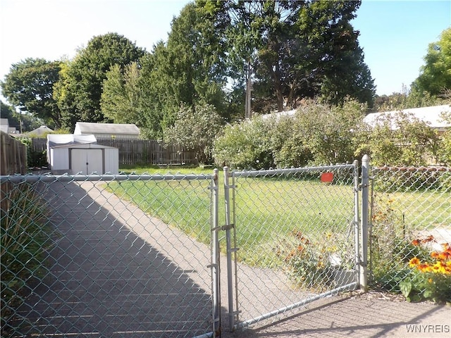 view of gate with a lawn and a storage shed