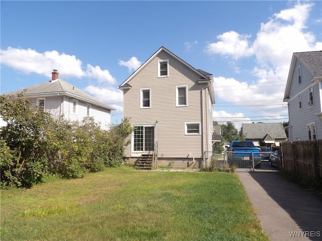 rear view of house featuring a yard