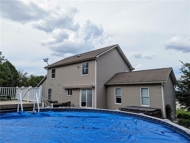 rear view of house with a pool side deck