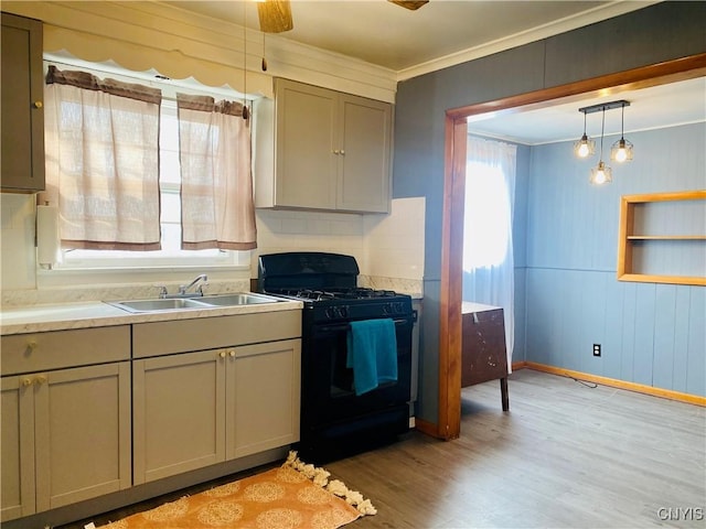 kitchen with sink, black gas range oven, light hardwood / wood-style flooring, gray cabinets, and ornamental molding