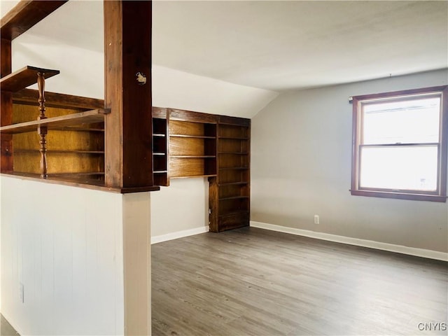 unfurnished living room featuring wood-type flooring and vaulted ceiling