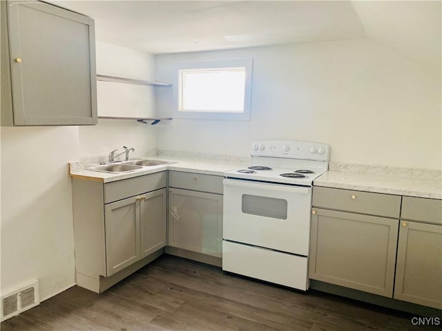 kitchen featuring electric range, sink, dark wood-type flooring, lofted ceiling, and gray cabinets