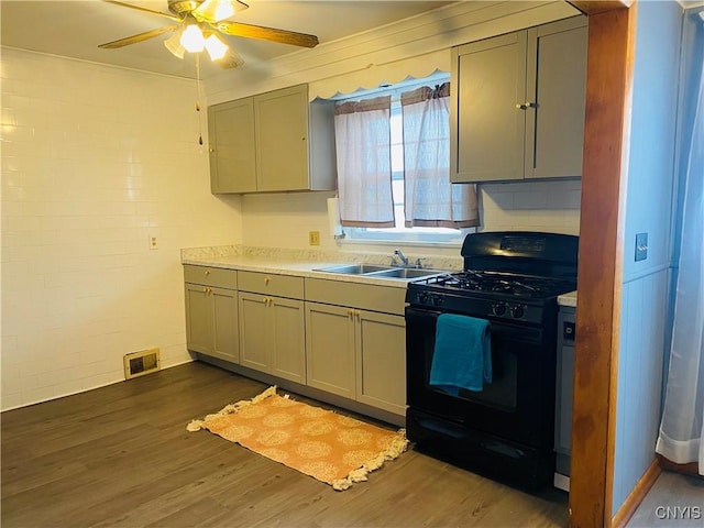 kitchen featuring dark hardwood / wood-style flooring, gas stove, gray cabinetry, and sink