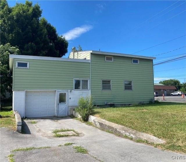 rear view of house with a yard and a garage