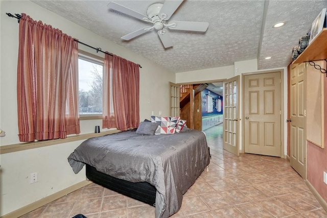 tiled bedroom with a textured ceiling and ceiling fan