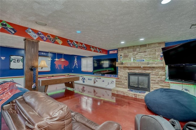 game room featuring pool table, concrete floors, a fireplace, and a textured ceiling