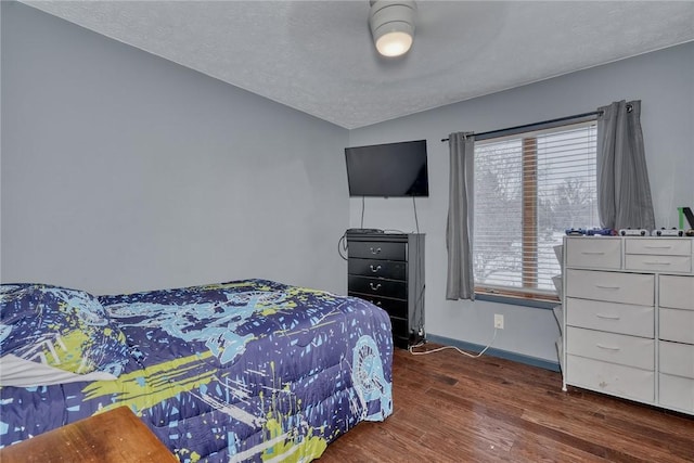 bedroom with a textured ceiling, ceiling fan, hardwood / wood-style floors, and lofted ceiling