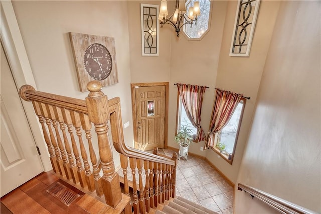 staircase with a high ceiling and tile patterned floors