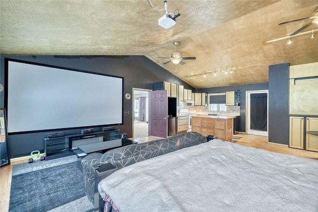 home theater room with vaulted ceiling, ceiling fan, and light hardwood / wood-style floors