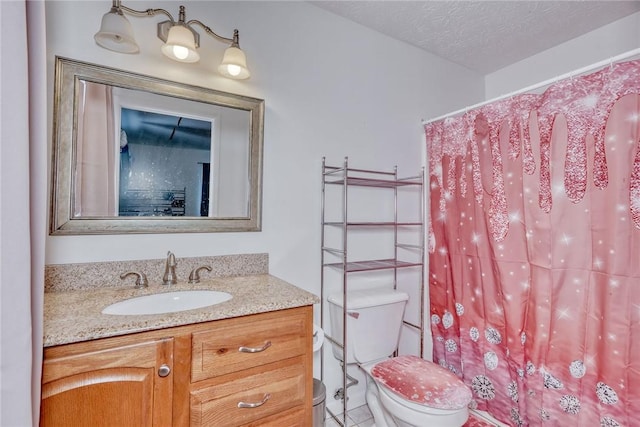 bathroom with toilet, a textured ceiling, and vanity