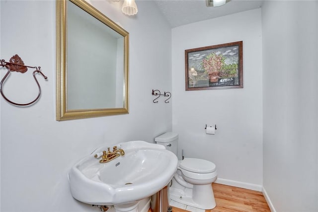 bathroom featuring sink, toilet, and hardwood / wood-style floors