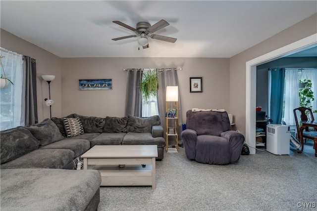 living room with ceiling fan, plenty of natural light, and carpet floors