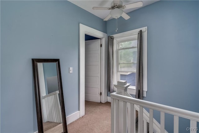 hallway featuring light colored carpet