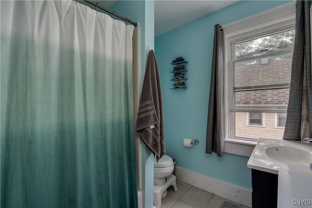 bathroom with toilet, vanity, and tile patterned floors