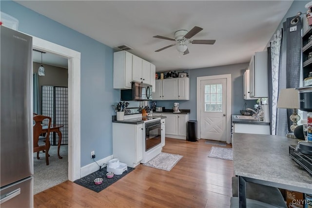 kitchen featuring ceiling fan, sink, stainless steel appliances, light hardwood / wood-style floors, and white cabinets