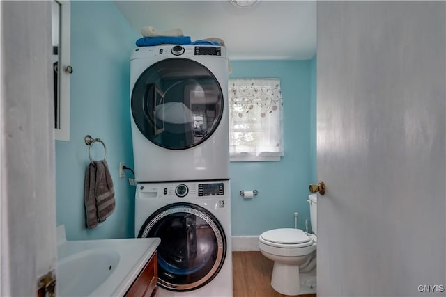 washroom featuring hardwood / wood-style floors and stacked washer and dryer