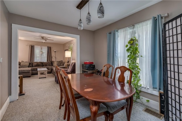 dining space featuring ceiling fan and light colored carpet