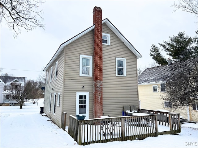 snow covered rear of property featuring a wooden deck