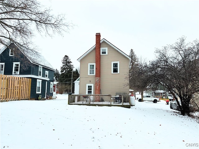 snow covered house featuring a deck