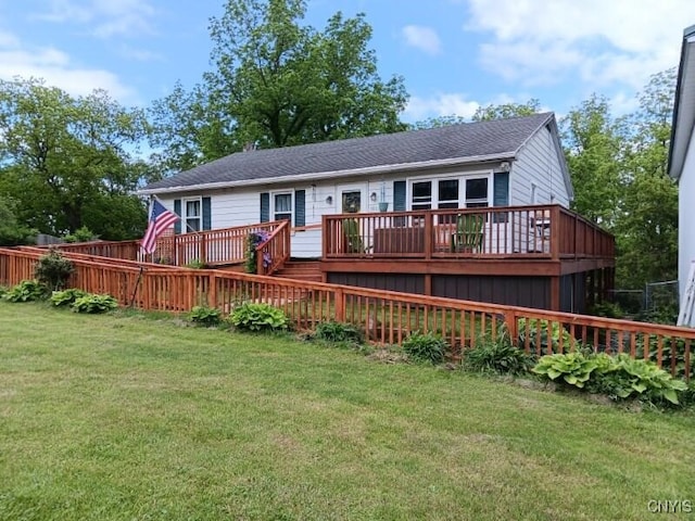 rear view of house featuring a lawn and a wooden deck