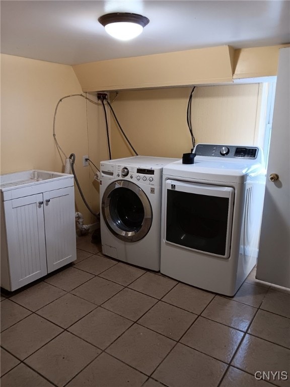 clothes washing area featuring washing machine and clothes dryer and light tile patterned floors