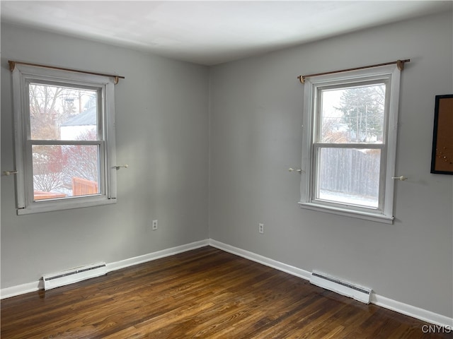 spare room with a baseboard radiator and dark hardwood / wood-style flooring