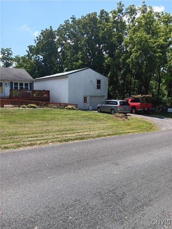 view of side of property with a lawn, a garage, and a wooden deck