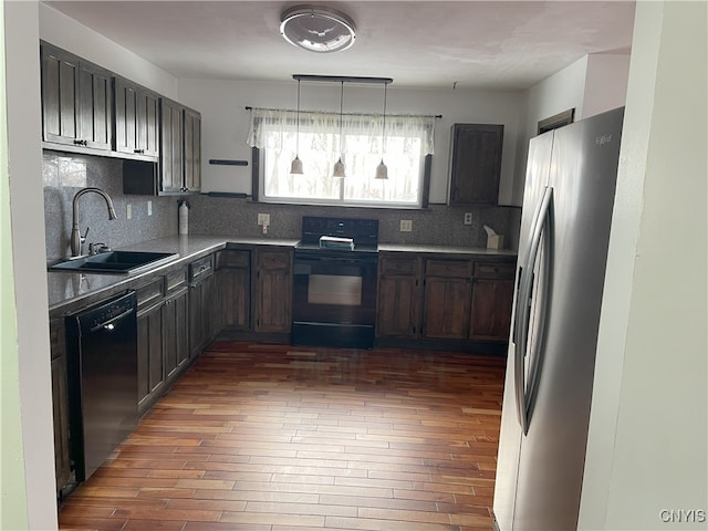 kitchen featuring black appliances, dark hardwood / wood-style floors, backsplash, and sink