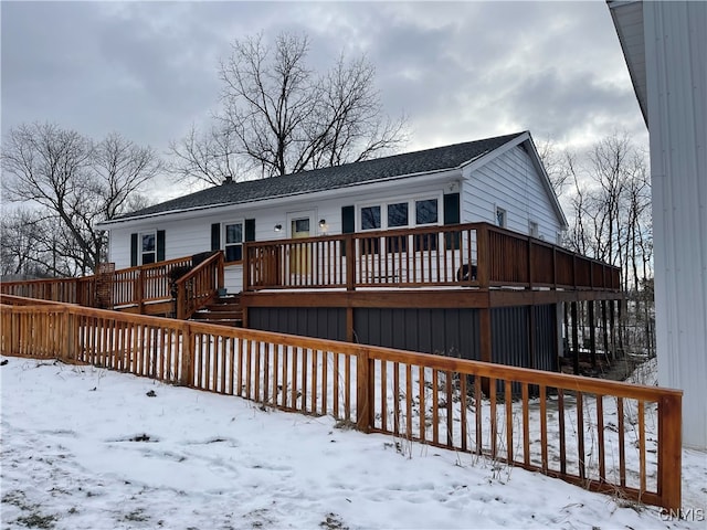 snow covered house with a deck