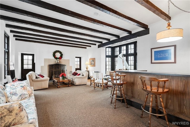 living room with bar area, a wealth of natural light, beamed ceiling, and dark colored carpet