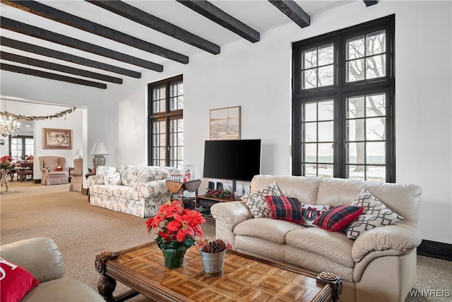 carpeted living room with beam ceiling and a chandelier