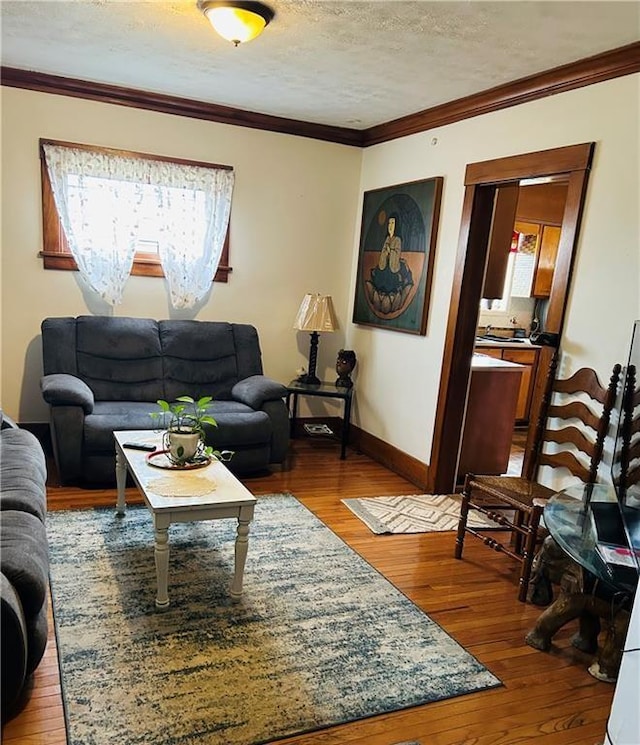 living room featuring hardwood / wood-style floors, a textured ceiling, and ornamental molding