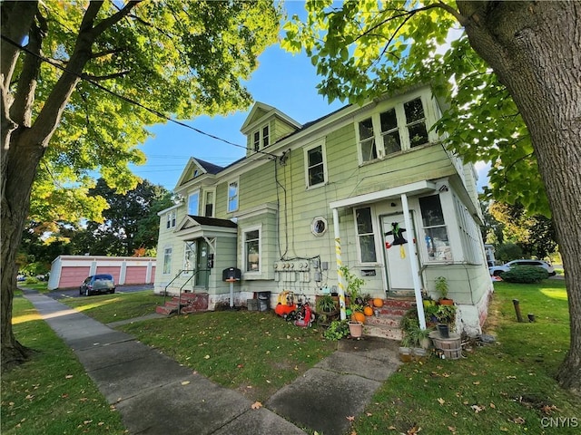 view of front of home featuring an outbuilding, a garage, and a front yard