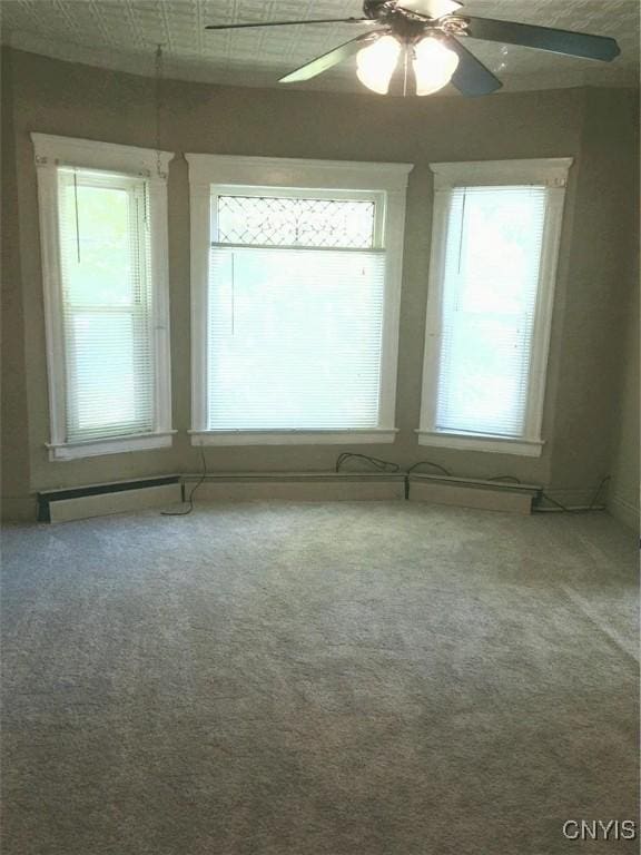 carpeted spare room featuring ceiling fan and a wealth of natural light