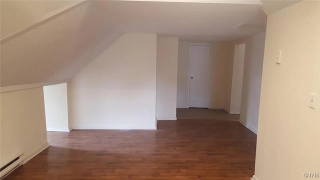 additional living space featuring lofted ceiling, a baseboard radiator, and dark hardwood / wood-style floors