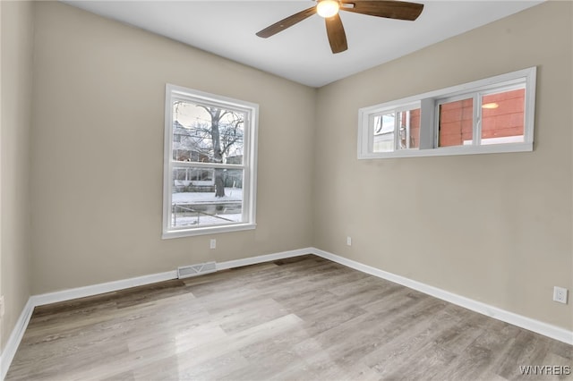 empty room with ceiling fan and light hardwood / wood-style floors