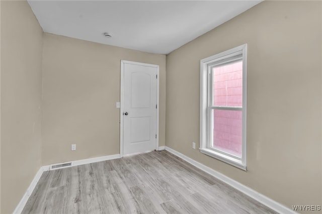 empty room featuring plenty of natural light and light hardwood / wood-style floors