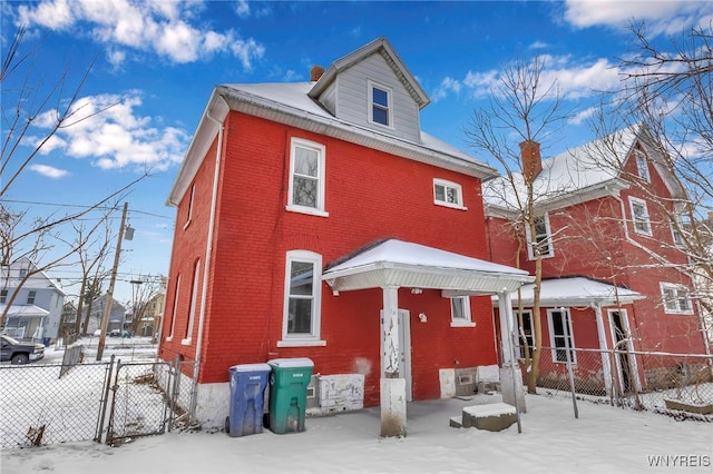 view of snow covered rear of property