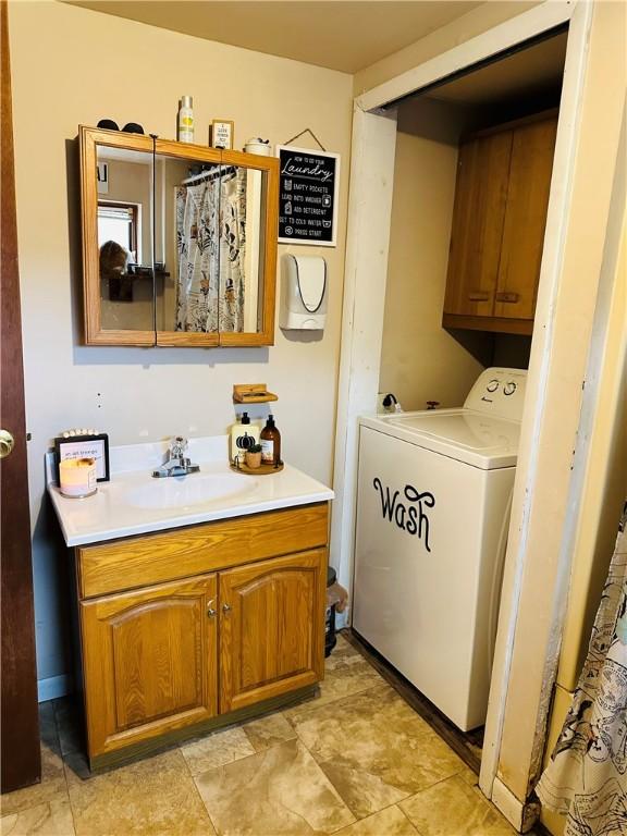 laundry room with cabinets, washer / dryer, and sink