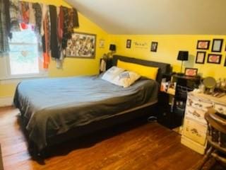 bedroom with dark hardwood / wood-style floors and lofted ceiling