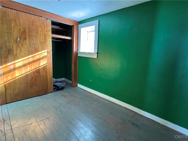 unfurnished bedroom with a closet and wood-type flooring