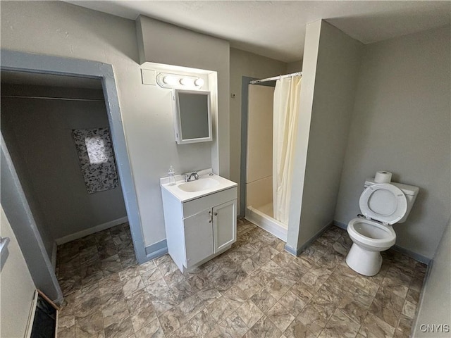 bathroom featuring toilet, vanity, and walk in shower