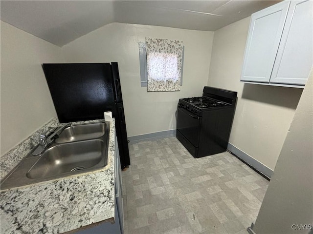 kitchen with white cabinets, black gas range oven, lofted ceiling, and sink