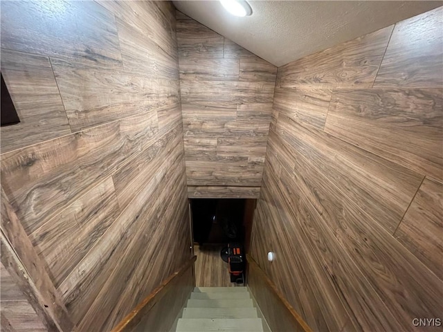 interior space featuring a textured ceiling and vaulted ceiling